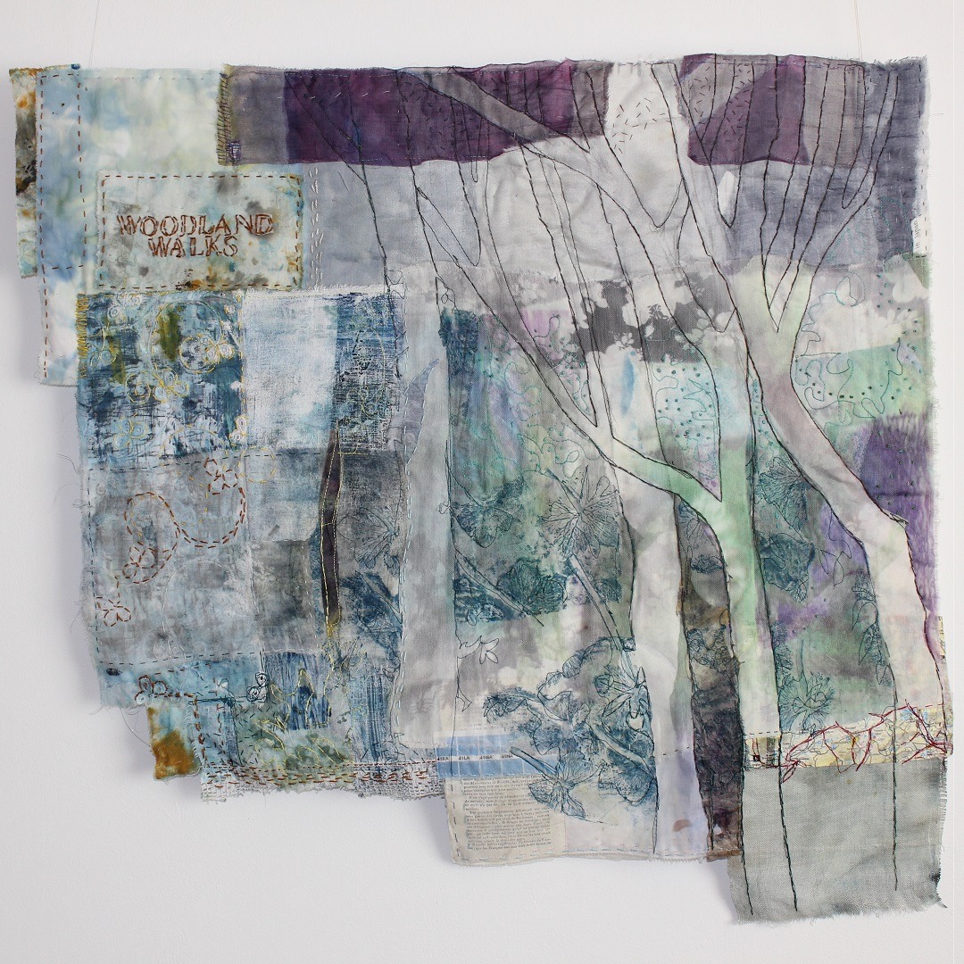 Textile art collage with embroidered tree outline