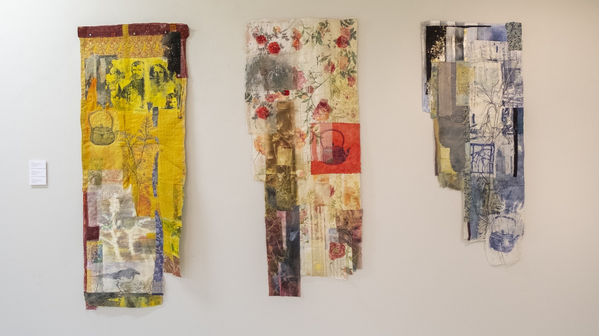 Three panels of textile art pieces hanging from the wall made up of colourful collage and embroidery