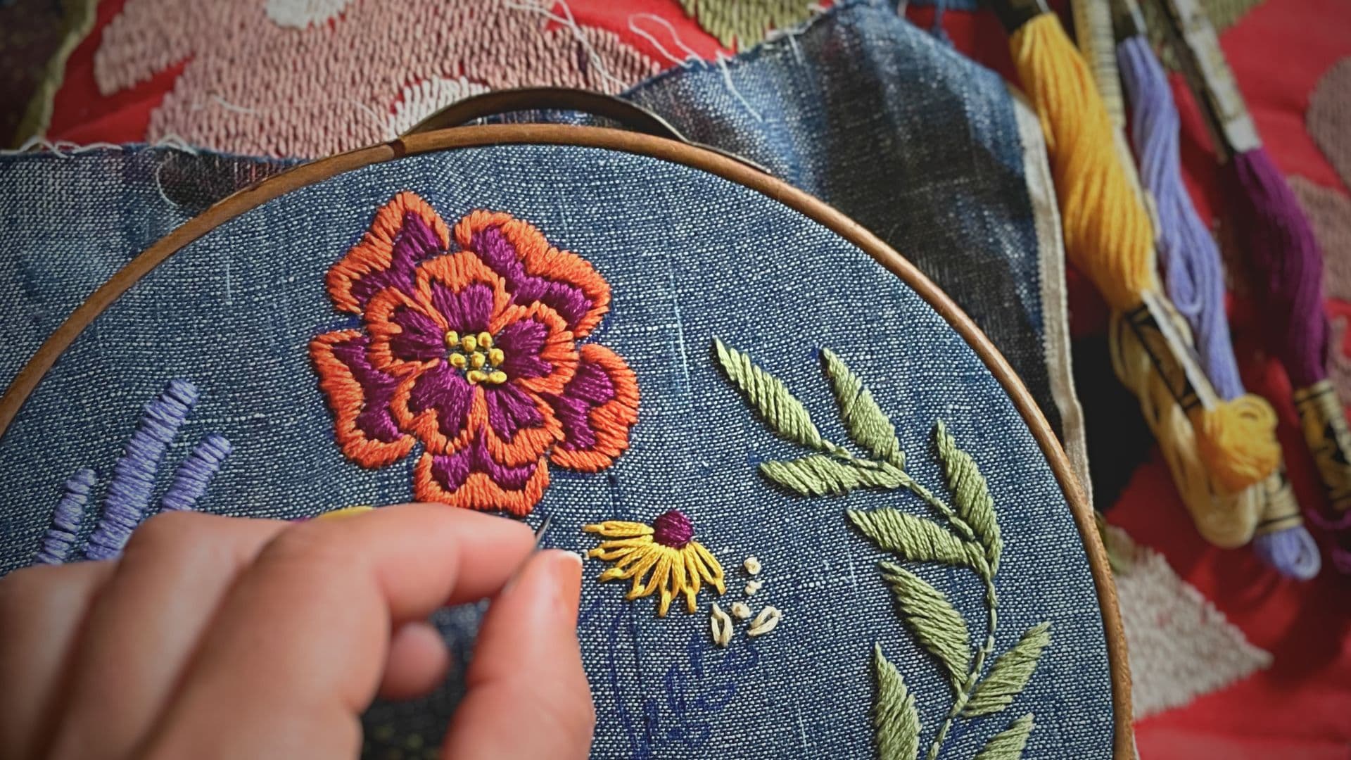 hand embroidering a flower on a hoop